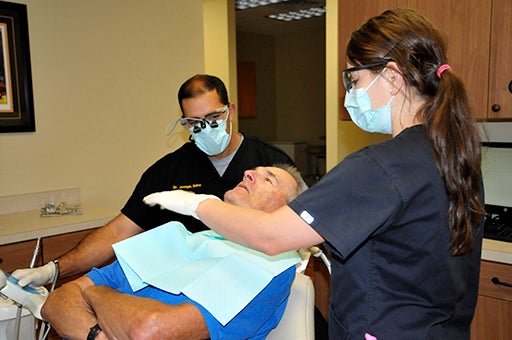 BRIGHT SMILE: Dr. Daho prepares to examine his patient’s teeth. Photo by Ashley Collins.