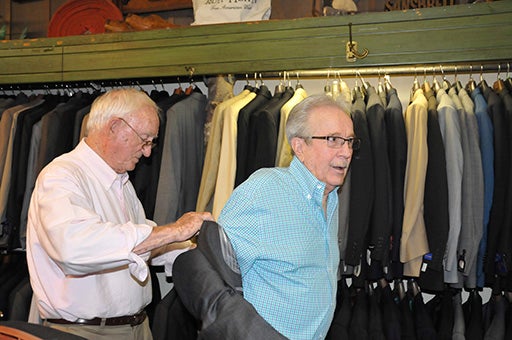 QUALITY SUITS: Apple’s Owner Robert Applewhite assists a customer into a suit jacket. The clothing store offers suits and tuxedos for sale and rental. Photo by Ashley Collins.