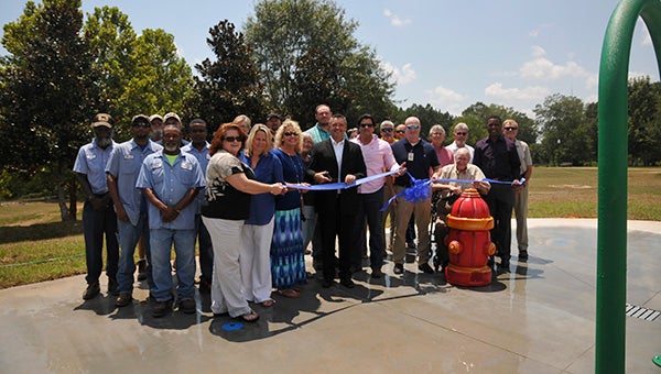 RIBBON CUTTING: Poplarville officials, public works employees, representatives from the Lower Pearl River Valley Foundation, Poplarville Rotary and other community members gathered Wednesday for a ribbon cutting at the city’s splash pad. The pad will officially open today during city park’s regular hours.  Photo by Cassandra Favre 