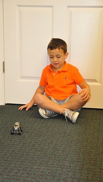 healthy and happy: Cole plays with his toy car. Photo by Cassandra Favre