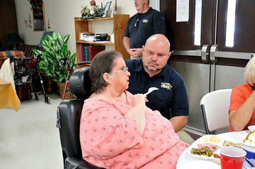 MAKING BONDS: Assistant Chief Jeremy Magri speaks to a Pines resident during the luncheon. Photo by Ashley Collins.