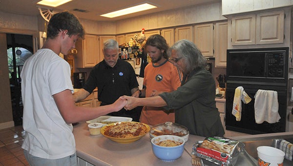 family in america: From left Kalle prays with Mark, Sam and Natalie Glorioso before every meal.  Photo by Cassandra Favre