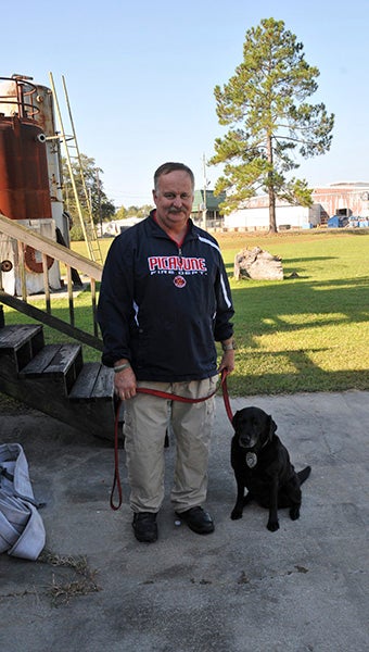 a dog and her trainer: From left, Picayune Fire Marshal Pat Weaver and Joanie pose for a picture after demonstrating training techniques. Joanie is by Weaver’s side at all times.  Photo by Cassandra Favre