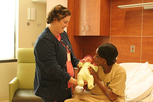 BRINGING JOY INTO THE WORLD: Highland Community Hospital RN Sarah Edgar, pictured on left, hands newborn Cheyenne to Chelciah Stacks. Photo by Ashley Collins.