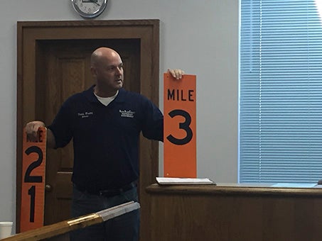 BETTER SIGNAGE: Pictured, Emergency Management Director and Fire Services Coordinator Danny Manley shows the county supervisors the mileage markers that will be placed on the Pearl River. Photo by Ashley Collins.