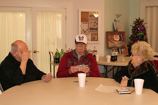SOCIAL SPACE: Pictured from left to right, Luke, Earl and Jane play cards at the Senior Center of South Pearl River County. Photo by Ashley Collins.
