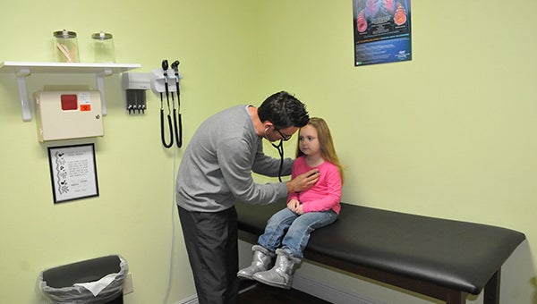 REGULAR CHECKUP: Christopher Fletcher, a nurse practitioner at Children’s International Medical Group in Picayune, performs an exam on 5-year-old Bella.  Photo by Cassandra Favre