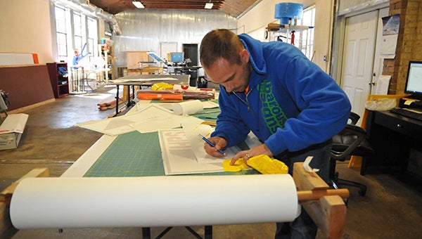 GRAPHIC DESIGN: Matt Barousse, co-owner of Picayune’s Barousse Designs, works on an order for a customer.  Photo by Cassandra Favre 
