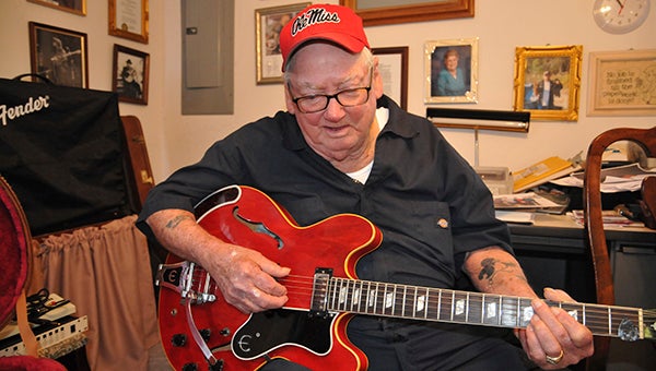 hold a guitar: Although his carpal tunnel won’t allow him to play, Toxie Baughman can still hold his 1967 Epiphone guitar.  Photo by Cassandra Favre