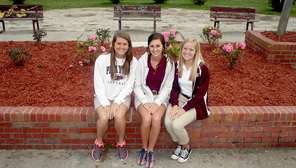 DONATED TIME: At top from left, Rylee Dawsey, Caroline Whitfield and Abby Montgomery pose in front of the memorial garden they worked on during spring break.   Photo by Jeremy Pittari
