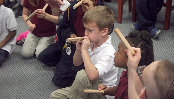 RED OAK: Students blow bubbles through pieces of red oak as part of a demonstration to show how the wood has vessels that transport water to the rest of the tree. White oak has special vessel blockers that makes it an ideal wood to build a boat.  Photo by Jeremy Pittari