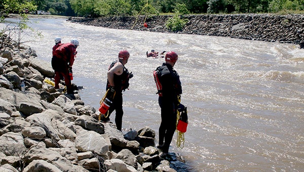 PLAYING CATCH: Firefighters from Brandon, Mississippi participating in swift water training at the Wilson Slough took turns getting in the water and throwing rescue ropes to those pretending to be victims.  Photo by Jeremy Pittari