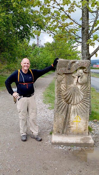 Fr. Filkins stands at the Santiago de Compostela marker outside of Santiago, Spain.  Photo submitted