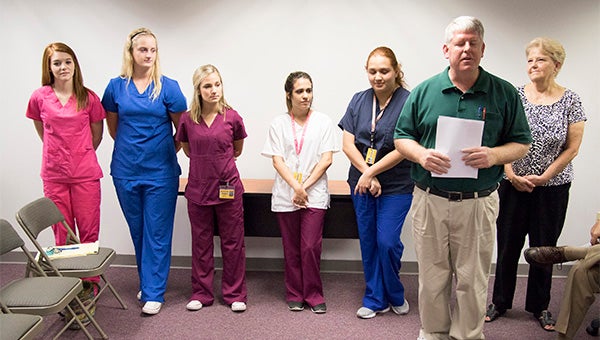 to a career: This year there are eight participants in the Picayune School District’s dual enrollment program for LPNs. From left are Jewlia Peoples, Amanda Fendley, Brooke Stevenson, Taylor Hood and Liliana Corona, LPN teacher Todd Smith and Career and Technology Director Jouan Lee. Not pictured are students Katie Williams, Hannah Bennett and Destiny Patterson.  Photo by Jeremy Pittari