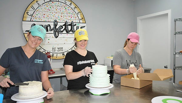 TOGETHER: This year, five Picayune women formed a co-op, The B.A.K.E. Project. From left, Colby Moeller, Brooke Rester and Katy Smith prepare their baked goods for Saturday. Not pictured are Brandi Pierce and Kimberly Kirby.  Photo by Cassandra Favre 