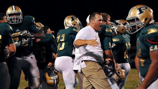 The Hornets’ Head Coach Jay Beech celebrates their comeback against Stone High School with his team. 