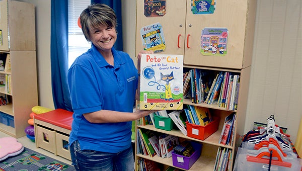 Daphne Stevens, program director at Early Years Network, shows off some of her favorite books in the resource center. Photo by Julia Arenstam 