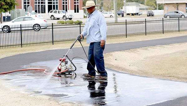 A city employee uses a pressure washer to remove the hydroseed that hit the new asphalt on Crosby Common’s walking track.  The track will open on Nov. 7 once all of the finishing touches are complete. When it opens, the walking track will only be open during daylight hours.   Photo by Jeremy Pittari