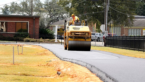 PARK IMPROVEMENTS: At top, contractors smooth out the asphalt that will make up the walking track at Crosby Commons. Photo by Jeremy Pittari
