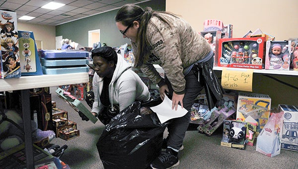 A volunteer for the Toys for Tots toy distribution assists a shopper pick out gifts for her children.
