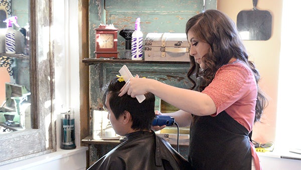 Cosmetologist Sadie Bordelon-Herring gives a male client a haircut at the Loft Salon in Poplarville. Photo by Julia Arenstam 