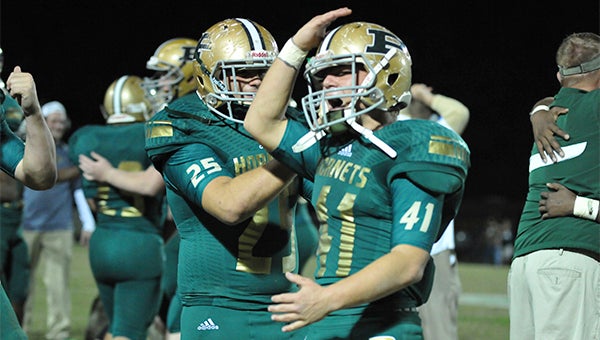 On to state: A couple of Poplarville Hornets celebrate after Friday's win that paved the way for the team to compete int he state championship on Saturday.  The team will be honored as the grand marshal int he Poplarville Christmas Parade on Friday.  Photo by Julia Arenstam 