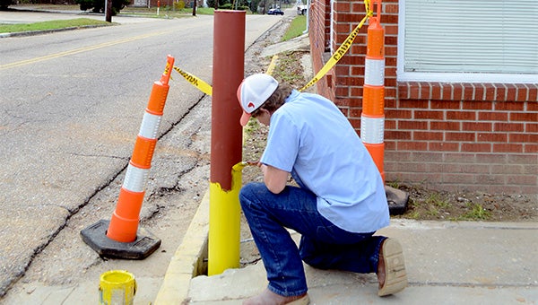 The Poplarville Public Works Department installed a new post outside the Poplarville Chamber of Commerce building Thursday after a log truck struck the building.  Photo by Julia Arenstam 