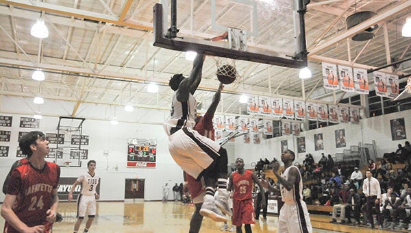 ROCK THE RIM: Stephane Ayangma flushes an alley-oop in the second quarter in the Picayune Christmas Tournament championship game against Lafayette.