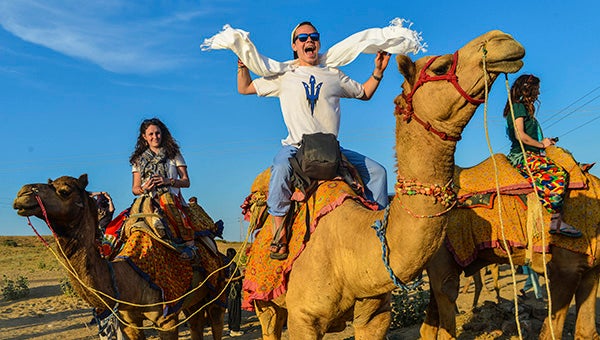 Bradley Booth, pictured in the middle, rides a camel in Jaisalmer.